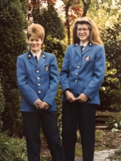 Oude foto van twee meisjes in het blauwe uniform van een harmonieorkest